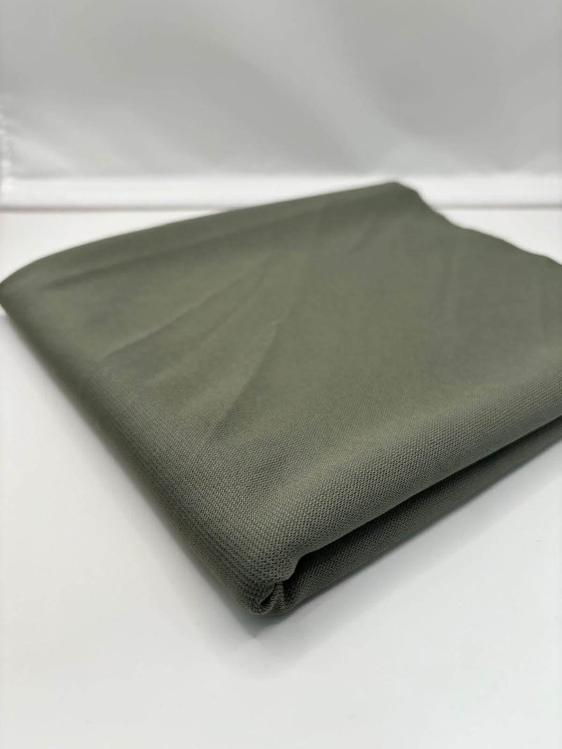 Khaki Green ponte roma fabric folded