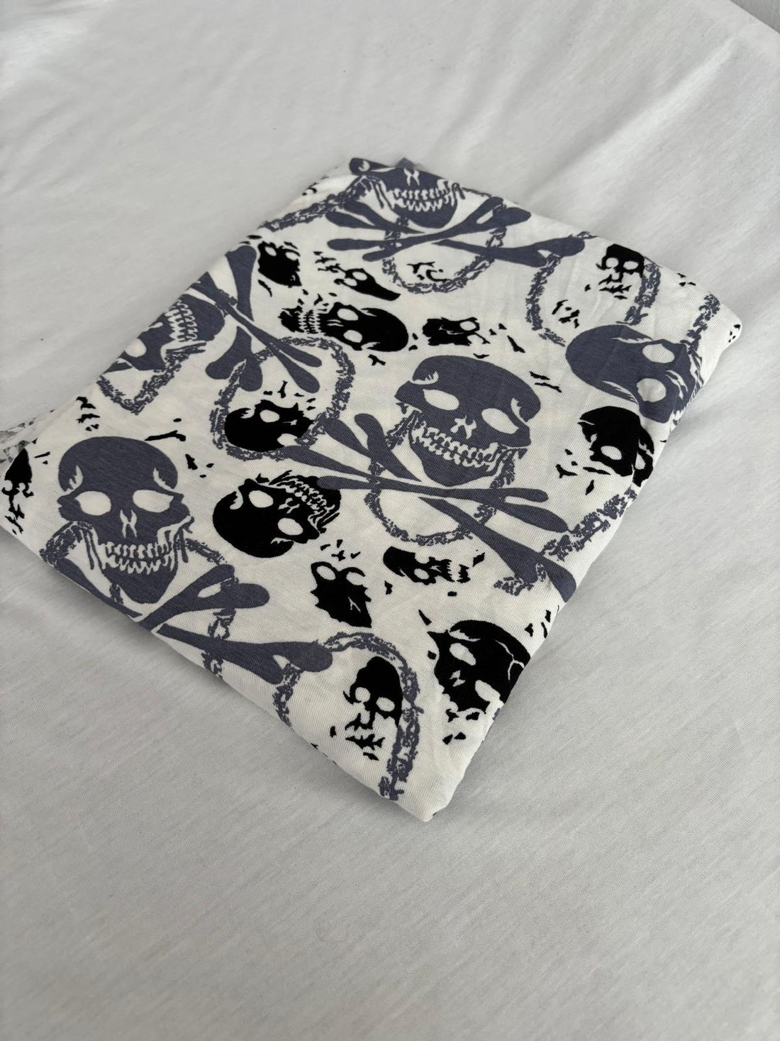 Skull and crossbones print viscose jersey fabric, folded